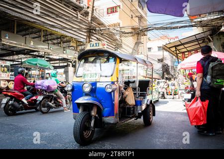 Un tuk tuk i fait son chemin à travers les rues animées du marché de Pratunam, Bangkok, Thaïlande. Banque D'Images