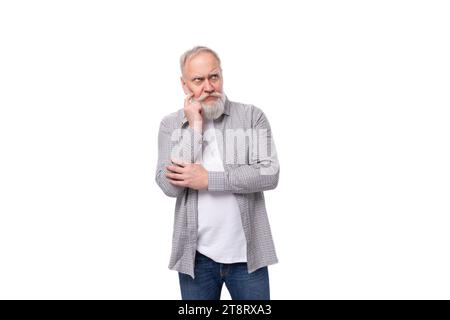 mignon grand-père intelligent avec une barbe blanche et une moustache habillée d'une chemise rayée sur un t-shirt pensé sur un fond blanc avec espace copie Banque D'Images