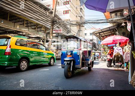 Un taxi tuk tuk fait son chemin à travers les rues animées du marché de Pratunam, Bangkok, Thaïlande. Banque D'Images