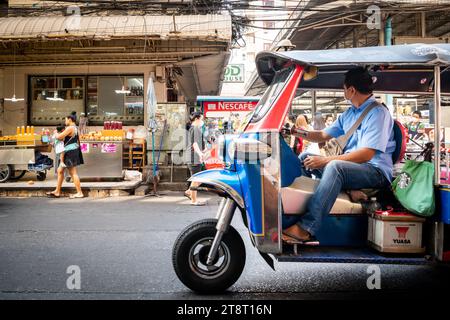 Un taxi tuk tuk fait son chemin à travers les rues animées du marché de Pratunam, Bangkok, Thaïlande. Banque D'Images