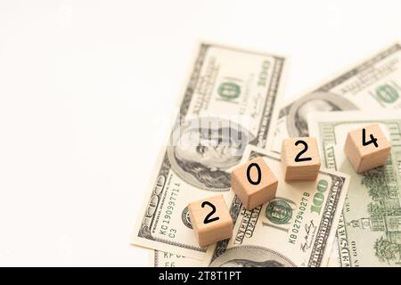 2024 inscription sur des cubes en bois sur la texture des dollars américains et des billets en euros Banque D'Images