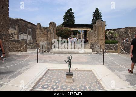 Ruines de Pompéi : Maison du faune avec copie de la statue du faune dansant, statue originale du musée archéologique de Naples. Vestiges de la ville romaine enterrés par l'éruption du mont. Vésuve en 79 AD et fouillé dans les temps modernes, Italie Banque D'Images