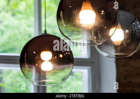 Abat-jour en verre rond avec lampes au tungstène incandescentes à l'intérieur, photo en gros plan d'un lustre moderne avec mise au point sélective Banque D'Images