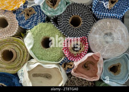 Gros plan de rouleaux empilés de tissu, exposés sur un marché de rue vendant des textiles. Manacor, île de Majorque, Espagne Banque D'Images