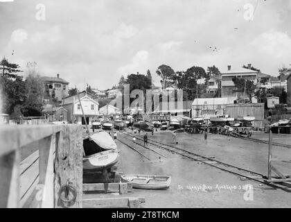 Shelly Beach, Auckland, Nouvelle-Zélande, vue prise du quai des yachts sur le bordereau d'atterrissage à St Marys Bay. Les entreprises de construction de bateaux et d'ingénierie peuvent être vues derrière les bateaux. Les garçons jouent au premier plan, vers 1914 Banque D'Images