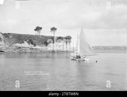 Hommes naviguant sur un bateau à Northcote, Auckland, Nouvelle-Zélande, Joseph Slattery et George Lepper dans 'Ranee' un bateau roulé de 24 pieds construit par Joseph Slattery naviguant au large de Northcote point. Auckland, ville de Nouvelle-Zélande peut être vu au loin à travers le port de Waitemata. Notez le marqueur de relevé trig à l'extrémité du point et le poteau téléphonique dans l'eau. La photographie a été prise avant que le flagstaff ne soit érigé sur la pointe vers 1908 Banque D'Images