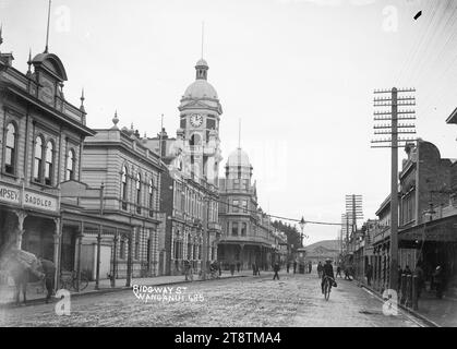 Vue de Ridgway Street, Wanganui, Nouvelle-Zélande, vue de Ridgway Street, Wanganui, Nouvelle-Zélande, en regardant vers le bureau de poste, avec la Watt Fountain à l'intersection avec Victoria Avenue à mi-distance. La tour de l'horloge du bureau de poste est visible au centre à gauche, la rue est bordée de boutiques, et il y a plusieurs vélos alignés devant le bureau de poste. Avant décembre 1908, lorsque la fontaine a été déplacée sur un autre site pour faire place au nouveau tramway, qui a été officiellement inauguré en décembre 1908 Banque D'Images