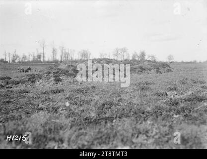 Un pieu bien camouflé près de Colincamps pendant la première Guerre mondiale, Un banc herbeux marque la place d'un pieu bien camouflé pour les troupes néo-zélandaises combattant près de Colincamps en France, première Guerre mondiale Plus loin en arrière-plan, certains soldats sont partiellement visibles dans un autre pirogue. Photographie prise le 15 avril 1918 Banque D'Images