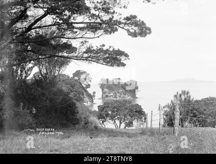 Le Tor, Waiakae Beach, Torbay, vue vers l'est avec le Tor à mi-distance et l'île de Rangitoto visible à l'horizon. Prise d'un point de vue au-dessus de Waiake Beach au début des années 1900 Banque D'Images