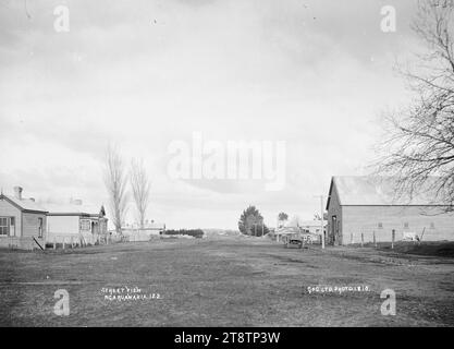 Vue sur la rue à Ngaruawahia, Nouvelle-Zélande, 1910 -, vue le long d'une large route à Ngaruawahia, Nouvelle-Zélande avec un grand bâtiment sur la droite, et une rangée de maisons sur la gauche. (Probablement Green & Colebrook, marchands, avec une succursale à Ngaruawahia, en Nouvelle-Zélande Banque D'Images