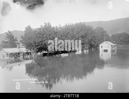 Rivière Waikato en inondation, à Ngaruawahia, Nouvelle-Zélande, vers 1910, vue de la rivière Waikato en inondation le long de l'esplanade Waikato, avec des maisons visibles derrière une rangée d'arbres, et le Ngaruawahia, New Zealand Rowing Club bâtiment partiellement inondé Banque D'Images