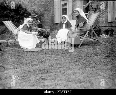 Matron Price à une Garden party dans le parc du New Zealand Stationary Hospital, France, Matron Frances Price, assise dans une chaise longue à droite, parle avec des infirmières et un soldat à une Garden party dans le parc du New Zealand Stationary Hospital, probablement à Hazebrouck, pendant la première Guerre mondiale Les infirmières ont été identifiées comme étant Mlle Scott et soeur Whittes. Photographie prise le 24 juin 1917 Banque D'Images