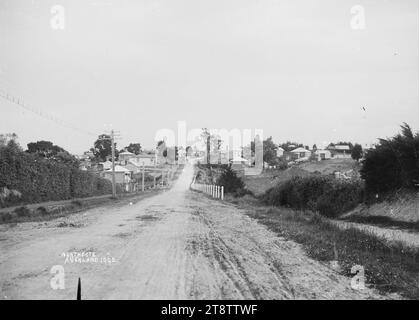 Vue regardant vers le bas Stafford Road, Northcote, Auckland, Nouvelle-Zélande, vue regardant vers l'ouest le long de Stafford Road, Northcote montrant des maisons des deux côtés et des lignes électriques et un sentier sur le côté gauche. Un groupe de garçons peut être vu debout en face de la clôture blanche à mi-distance. L'église méthodiste wesleyenne Northcote peut être vue au sommet de la route. Prise, pré-1920 Banque D'Images