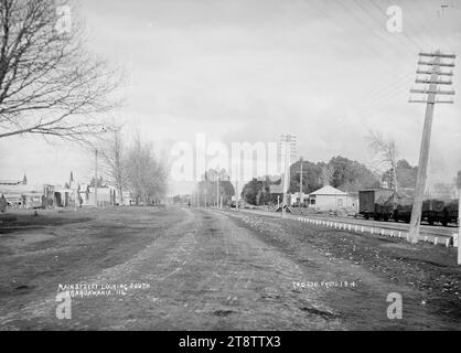 Great South Road, la rue principale à travers Ngaruawahia, Nouvelle-Zélande, vue sud, 1910 -, vue le long de la Great South Road, la rue principale à travers Ngaruawahia, Nouvelle-Zélande, vue sud. La ligne de chemin de fer entre à droite, et il y a une rangée de magasins au centre à gauche. (Probablement Green & Colebrook, marchands, avec une succursale à Ngaruawahia, en Nouvelle-Zélande Banque D'Images