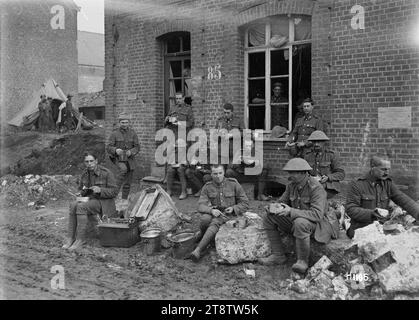 Wellington, Nouvelle-Zélande soldats mangeant un repas à Solesmes, France, première Guerre mondiale, des soldats d'un régiment de Wellington, Nouvelle-Zélande s'assoient mangeant un repas dans des boîtes de mess dans la ville française de Solesmes pendant la première Guerre mondiale Ils utilisent des morceaux de maçonnerie cassés comme sièges et tables. Photographie prise le 9 novembre 1918 Banque D'Images