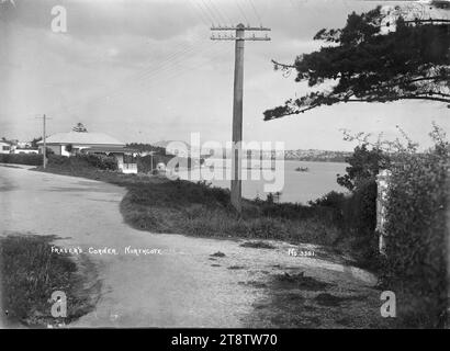 Vue de Fraser's Corner, Northcote, en regardant vers Auckland, Nouvelle-Zélande, vue vers le sud vers Northcote Wharf avec Mount Eden et Auckland, ville de Nouvelle-Zélande au loin. À gauche se trouve une maison surplombant Little Shoal Bay et le port de Waitemata. Les lignes électriques bordent la route. Un ferry vient de décoller du quai. Prise ca 1910 d'Auckland, Nouvelle-Zélande Banque D'Images