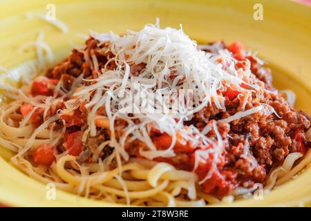 Pâtes bolognaises parsemées de parmesan râpé dans un plat profond Banque D'Images