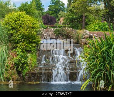 Prise dans le parc du Bishops Palace à Wells, Somerset Angleterre, Royaume-Uni, à l'été 2022, montrant une passerelle au-dessus d'une cascade dans le jardin de Wells. Banque D'Images