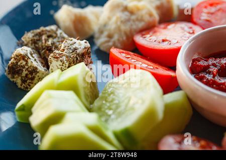 Apéritifs, collations, fromages, tranches de concombres et tomates, sauce piquante, sur assiette, mise au point sélective. Banque D'Images