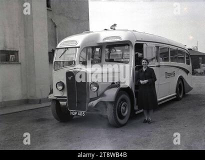 Années 1950, historique, une jeune femme debout à côté d'un autocar d'excursion de Timpson, un AEC Regal, avec un panneau indiquant « Surrey Tour », Angleterre, Royaume-Uni. Une société Timpson & Sons Ltd de Rushey Green, Catford, Londres, SE6, une entreprise fondée en 1912 par Alexander Timpson, a exploité des services d'autocars à de nombreuses stations balnéaires populaires de la côte sud en Angleterre à cette époque. Banque D'Images