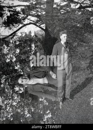 années 1950, historique, un homme debout pour sa photo dehors avec une dame «fantôme» dans la photo. L'effet fantôme se produit lorsque vous avez une double exposition dans une seule image. Banque D'Images