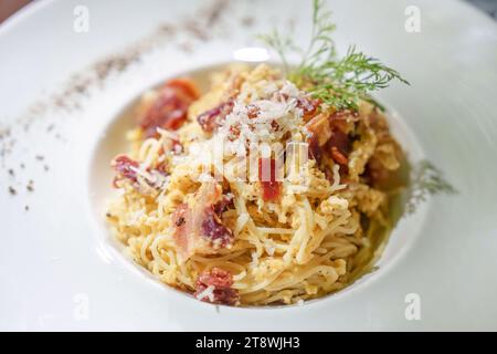 Gros plan sur le menu de fromage parmesan au bacon spaghetti carbonara dans un plat blanc dans un restaurant de bon goût Banque D'Images