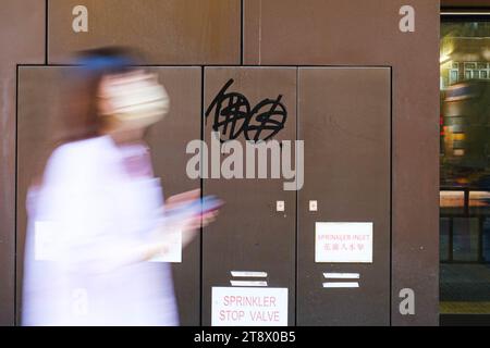 Hong Kong, Chine. 21 novembre 2023. Un graffiti avec les caractères chinois du mot « liberté » et des signes du dollar est visible sur un mur. Un artiste de 40 ans nommé Chan King-fai a été arrêté pour avoir prétendument vandalisé diverses structures et installations publiques à travers l'île de Hong Kong, Kowloon et les nouveaux Territoires de janvier à février. Il a reconnu sa culpabilité à l'accusation de dommages criminels. (Image de crédit : © Keith Tsuji/ZUMA Press Wire) USAGE ÉDITORIAL SEULEMENT! Non destiné à UN USAGE commercial ! Banque D'Images