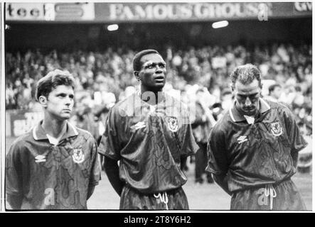 G-D David Phillips, Eric Young et Mark Aizlewood pendant les hymnes. Coupe du monde de la FIFA 1994 qualification Groupe 4 – pays de Galles contre RCS (Tchécoslovaquie alias représentation des Tchèques et des Slovaques) au Cardiff Arms Park, pays de Galles, Royaume-Uni, le 8 septembre 1993. Une victoire pour le pays de Galles dans ce match garantirait presque la qualification avec 2 matchs de groupe restants. Ils ont mené 2-1 mais ont concédé un but de coup franc tardif de Peter Dubovský et le match s'est terminé 2-2. Photo : Rob Watkins Banque D'Images