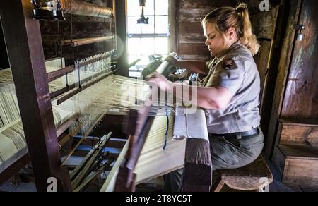 Park ranger démontre l'utilisation d'un métier à tisser à main pour fabriquer du tissu, Mabry Mill, Blue Ridge Parkway, Virginie, États-Unis Banque D'Images