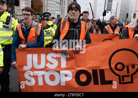 Londres, Royaume-Uni. 21 novembre 2023. Les militants pour le climat de Just Stop Oil tentent de ralentir march Down Whitehall pour exiger la fin des nouvelles licences d’extraction de combustibles fossiles dans un contexte d’urgence climatique. La police a rapidement publié un avis en vertu de l'article 7, arrêtant ceux qui refusaient de quitter la route en vertu des nouveaux pouvoirs anti-protestation prévus par la loi sur l'ordre public. Crédit : Ron Fassbender/Alamy Live News Banque D'Images