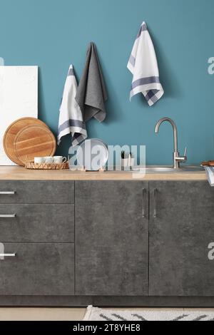Comptoirs de cuisine gris avec planches à découper, évier et ustensiles Banque D'Images