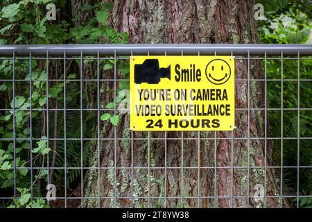 Signe de vidéosurveillance sur une porte métallique dans la forêt, Oregon Banque D'Images