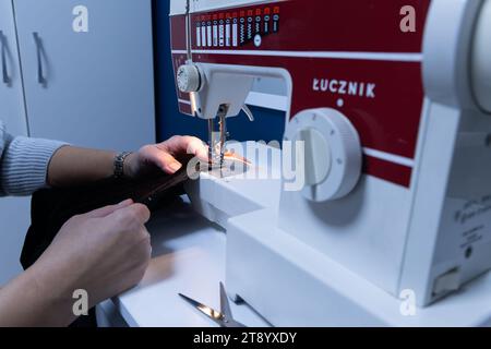 Coudre sur une machine à la maison dans un atelier de tailleur, réparer de vieux vêtements Banque D'Images