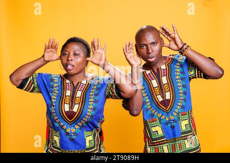 Couple afro-américain se trompant et montrant un portrait stupide grimace ensemble. Un homme et une femme joyeux s'amusent, posent avec une expression de visage comique et regardent la caméra Banque D'Images