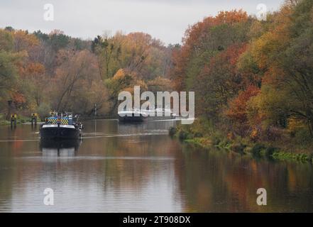 Kleinmachnow, Allemagne. 21 novembre 2023. Les barges Carrera et Zula 1 longent le canal Teltow en direction de l'écluse sur fond d'arbres d'automne feuillus. Crédit : Soeren Stache/dpa/Alamy Live News Banque D'Images