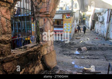 Naplouse, Palestine. 21 novembre 2023. Des Palestiniens vus marchant dans une rue endommagée du camp de réfugiés de Balata en Cisjordanie. Les conséquences d'un raid israélien dans le camp de réfugiés de Balata en Cisjordanie, alors que la violence s'intensifie dans le territoire palestinien occupé au milieu de la guerre d'Israël contre le Hamas à Gaza. Crédit : SOPA Images Limited/Alamy Live News Banque D'Images