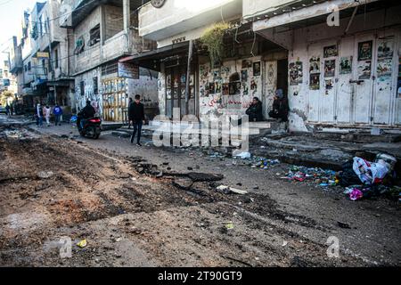 Naplouse, Palestine. 21 novembre 2023. Des Palestiniens passent devant une rue endommagée dans le camp de réfugiés de Balata en Cisjordanie. Les conséquences d'un raid israélien dans le camp de réfugiés de Balata en Cisjordanie, alors que la violence s'intensifie dans le territoire palestinien occupé au milieu de la guerre d'Israël contre le Hamas à Gaza. (Photo de Nasser Ishtayeh/SOPA Images/Sipa USA) crédit : SIPA USA/Alamy Live News Banque D'Images