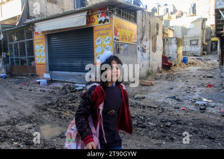 Naplouse, Palestine. 21 novembre 2023. Un enfant palestinien passe devant une rue endommagée dans le camp de réfugiés de Balata en Cisjordanie. Les conséquences d'un raid israélien dans le camp de réfugiés de Balata en Cisjordanie, alors que la violence s'intensifie dans le territoire palestinien occupé au milieu de la guerre d'Israël contre le Hamas à Gaza. (Photo de Nasser Ishtayeh/SOPA Images/Sipa USA) crédit : SIPA USA/Alamy Live News Banque D'Images