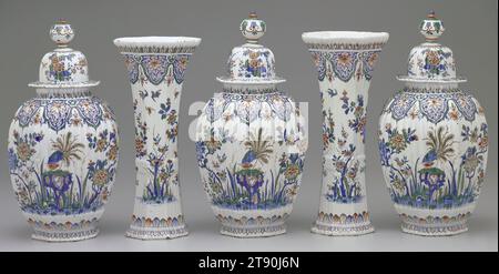 Vase couvert, d'un ensemble de garniture de cinq pièces, c. 1710, 17 1/4 x 7 15/16 x 8 1/2 po. (43,8 x 20,2 x 21,6 cm), Delftware avec vitrage polychrome, pays-Bas, 18e siècle, Une garniture est un ensemble d'articles, généralement des vases, dont le seul but est de décorer, et les garnitures à cinq pièces étaient la décoration la plus prestigieuse pour une cheminée ou le dessus d'une armoire. Cet ensemble a été fabriqué aux pays-Bas, mais sa décoration d'oiseaux et de fleurs, ainsi que sa palette de couleurs de bleu et blanc avec orange et vert, s'inspire de porcelaine chinoise importée, qui a été largement admirée mais trop chère Banque D'Images