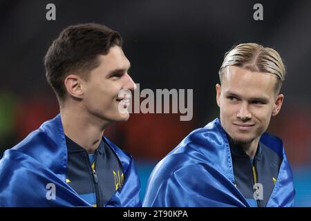 Leverkusen, Allemagne, 20 novembre 2023. Mykhailo Mudryk d'Ukraine réagit avec son coéquipier Georgiy Sudakov d'Ukraine alors qu'ils regardent les drapeaux ukrainiens attachés autour du cou avant le coup d'envoi du match de qualification pour le Championnat d'Europe de l'UEFA à BayArena, Leverkusen. Le crédit photo devrait se lire : Jonathan Moscrop / Sportimage Banque D'Images