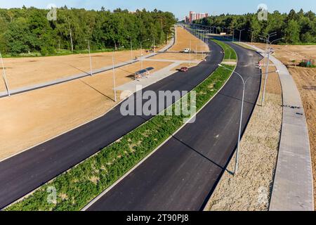 Vue d'une nouvelle autoroute à deux voies en construction traversant l'espace ouvert et la forêt Banque D'Images