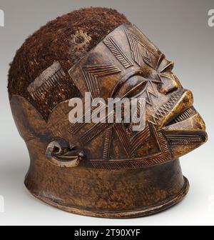 Masque, 1950s, 8 5/8 x 6 x 9 1/4 pouces (21,9 x 15,2 x 23,5 cm), Bois, cheveux, Mozambique, 19e-20e siècle, avant que le Mozambique ne gagne son indépendance du colonialisme portugais en 1975, les hommes et les femmes Makonde ont considérablement modifié leur corps au nom de la beauté, comme le montre ce masque. La modification a commencé à la puberté comme une étape importante vers la maturité et l'appartenance culturelle, animant le visage et encadrant les traits avec des tatouages, des dents ébréchées et une chevelure rasée. Les hommes portaient des masques en bois comme celui-ci lors de spectacles de danse publics, accompagnés de batteurs et d'un chœur. Banque D'Images