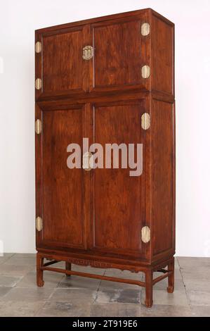 Armoire de garde-robe composée, un d'une paire, début du 18e siècle, 98 1/4 x 49 x 21 7/8 po. (249,6 x 124,5 x 55,6 cm) (assemblé), Huang-hua-li bois dur et baitonghardware, Chine, 18e siècle, la plus grande forme de cabinet chinois est la monumentale armoire composée d'angle carré. Toujours faite par paires, la forme se compose d'une grande unité inférieure surmontée d'une unité supérieure plus courte ou «poitrine à chapeau» construite à partir des mêmes matériaux. Ces armoires ont été conçues principalement pour le stockage de vêtements fins qui ont été pliés et posés à plat plutôt que suspendus. Banque D'Images