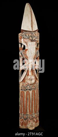 Figurine Malagan, c. 1890, inconnue, 78 x 13 1/2 x 12 po. (198,12 x 34,29 x 30,48 cm), Bois, pigment, coquille, Papouasie-Nouvelle-Guinée, 19e siècle, cette grande figure tient un instrument appelé katoviso, qui comprend un groupe de pipes de bambou qui sont jouées en soufflant à travers le dessus. Le chapeau de pluie du Piper, fait d'une feuille de pandan, est typique pour les femmes. Les sculptures stylisées de serpents qui composent la jupe représentent la connexion de la femme au monde spirituel. Les serpents apparaissent fréquemment dans l'art de la Nouvelle-Irlande en raison de leurs pouvoirs surnaturels. Cette figure représente probablement un ancêtre du clan Banque D'Images
