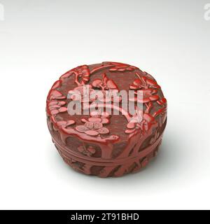Petite boîte avec couvercle, fin du 15e siècle, 1 9/16 x 3 1/4 x 3 1/4 po. (4 x 8,3 x 8,3 cm), laque rouge sculptée (tihong), Chine, 15e siècle, cette délicate boîte ronde contenait autrefois de l'encens aromatique. Il est sculpté partout avec des branches de prunes fleuries, serties sur un fond géométrique incisé destiné à suggérer le ciel. Au début des années 1500, des motifs géométriques répétés avaient trouvé leur chemin dans la laque sculptée avec des motifs floraux. Certaines familles de motifs géométriques ont été utilisées pour représenter le ciel, l'eau et la terre. Tandis que les motifs de terrain ont été pris à partir de motifs textiles géométriques Banque D'Images