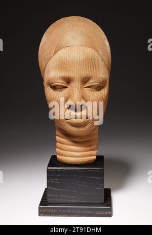 Tête de sanctuaire, 12e-14e siècle, 12 1/4 x 5 3/4 x 7 1/4 po. (31,1 x 14,6 x 18,4 cm), Terracotta, Nigeria, 12e-14e siècle, le comportement tranquille et le regard introspectif de cette tête expriment ce que les peuples Yoruba considèrent comme la vertu intérieure d’une personne. C'est une tête de portrait commémorative qui vient de la ville royale d'IFE dans l'ouest du Nigeria, un centre de pouvoir économique, religieux et politique entre 1100 et 1400. Les anciens artistes yoruba fabriquaient des têtes en bronze et en terre cuite qui faisaient partie de figures complètes ou, comme ici, autoportantes. Banque D'Images