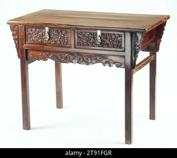 Table à deux tiroirs, 17e siècle, 34 1/8 x 43 13/16 x 24 11/16 po. (86,68 x 111,28 x 62,71 cm), bois dur Huang-hua-li, Chine, 17e siècle, bien qu'utile pour le stockage de petits objets, les tables à pieds encastrés avec tiroirs n'apparaissent pas souvent dans les gravures sur bois ou les peintures des Ming tardives et relativement peu ont survécu. La dernière édition Ming du manuel du menuisier lu Ban Ching illustre cependant une femme utilisant une table à deux tiroirs comme celle-ci en combinaison avec un support de miroir comme coiffeuse. La somptueuse sculpture de branches de prunes fleuries sur les façades des tiroirs est décoration Banque D'Images