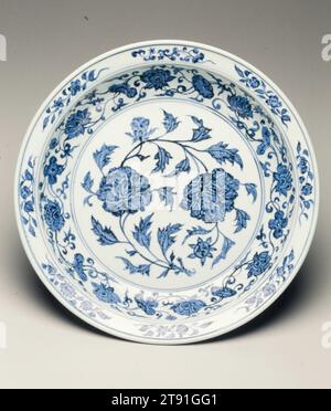 Plat, période du règne de Yongle, 1403-1424, 2 15/16 x 15 3/4 po. (7,46 x 40,01 cm), Jingdezhen ware porcelaine avec décor bleu cobalt sous glaçure, Chine, 15e siècle, peint avec deux fleurs de pivoine luxuriantes au centre, cet exemple exceptionnel de bleu et blanc des premiers Ming est remarquable pour son design audacieux, la douceur du travail au pinceau et l'ombrage subtil et contrôlé. Le travail montre les taches saturées 'entassées et empilées' de bleu cobalt intense trouvées dans les meilleures porcelaines de l'ère Yongle (1403-24) Banque D'Images