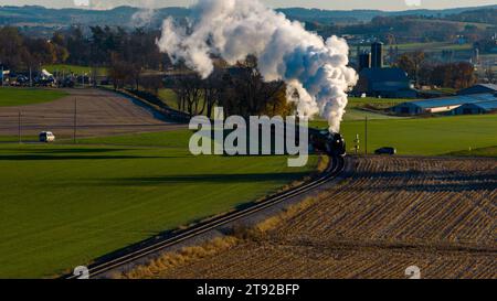 L'invention concerne un moteur à vapeur industriel émettant un flux de vapeur sur fond d'un champ verdoyant luxuriant. Banque D'Images