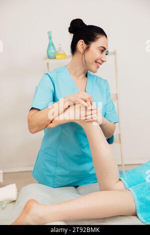 Masseur féminin faisant un massage thérapeutique médical des pieds dans un spa Banque D'Images